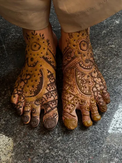 This Pakistani-style foot mehendi features large, prominent circular motifs, filled with delicate patterns. It's a classic look for a bride.
