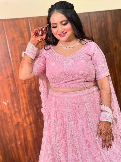 A playful pose from the bride, showing her happiness and the beautiful details of her pink lehenga.