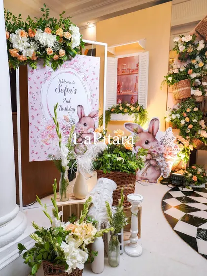 The welcome area for Sofia's party, with a personalized sign, bunny cutouts, and beautiful floral displays.