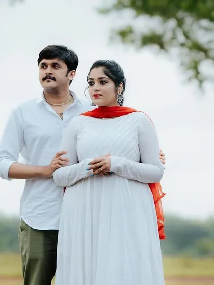 A portrait of a couple standing together in a field, looking out towards their future. The simplicity of the setting allows their connection to be the main focus.