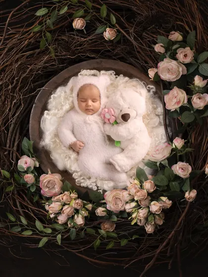 A fine art portrait of a sleeping baby, nestled in a floral wreath. This image showcases the artistic and delicate side of newborn photography, where I use creative setups to turn a simple portrait into a piece of art you will cherish forever.