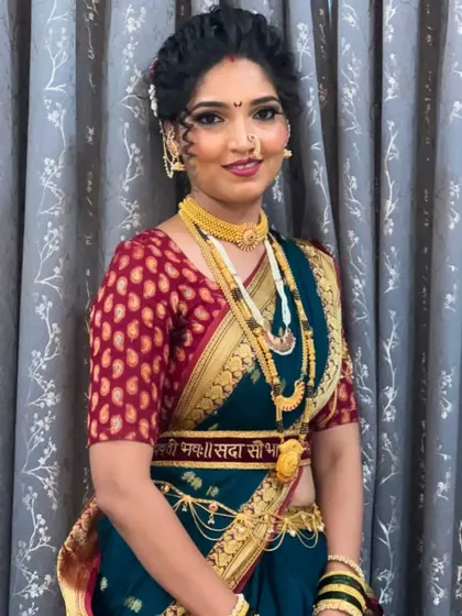 A direct portrait of the Maharashtrian bride, showing her warm smile and the classic makeup look that enhances her features without overpowering them.