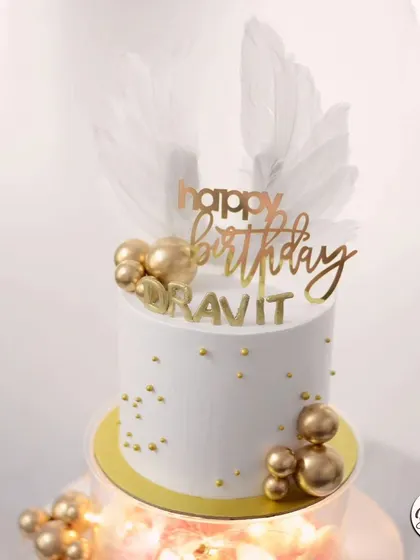 A close-up of the elegant topper, with its white feathers and golden details.