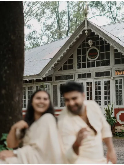 A blurry, dreamlike shot of the couple in front of a heritage building, capturing a moment of pure, uninhibited joy.