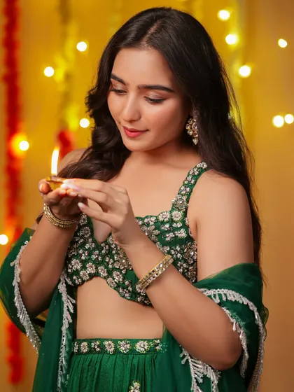 A candid moment from our Diwali shoot, capturing the model's gentle interaction with the diya. The warm, festive background enhances the celebratory mood.
