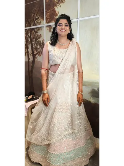 This bride is ready for her reception in a beautiful pastel lehenga. We opted for a soft smokey eye and a curly half-updo for a romantic and modern look.