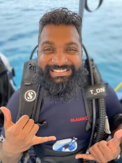 The classic 'shaka' sign from a happy diver. It's the universal symbol for 'hang loose' and perfectly captures the vibe of our dive trips.