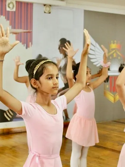 Arms raised high. Our Primary students learn the fundamentals of posture and port de bras (the carriage of the arms), building a strong base for more advanced techniques later on.