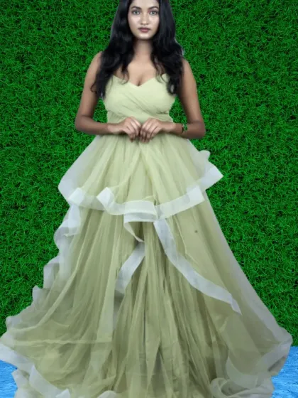 A light olive-green gown with a layered, asymmetrical design. The white ribbon accents add a modern and artistic flair to this unique outfit.