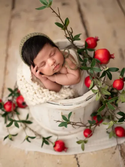 A sweet close-up of the newborn boy in the bucket, showing his tiny hand resting on his cheek. These are the details you'll want to remember forever.