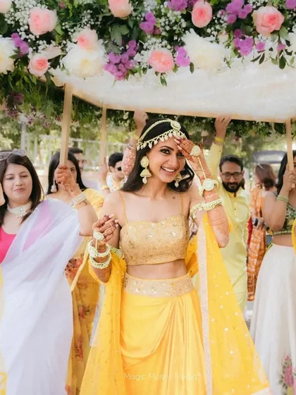 The bride's entrance under a floral 'phoolon ki chadar', a beautiful tradition elevated with a canopy of fresh pink, purple, and white flowers.