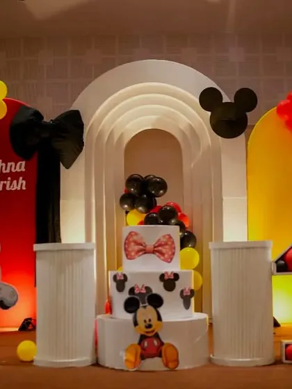 A classic Minnie and Mickey Mouse theme with a modern twist. The setup uses bold red, yellow, and black colors with arched backdrops and a custom cake featuring the iconic characters.