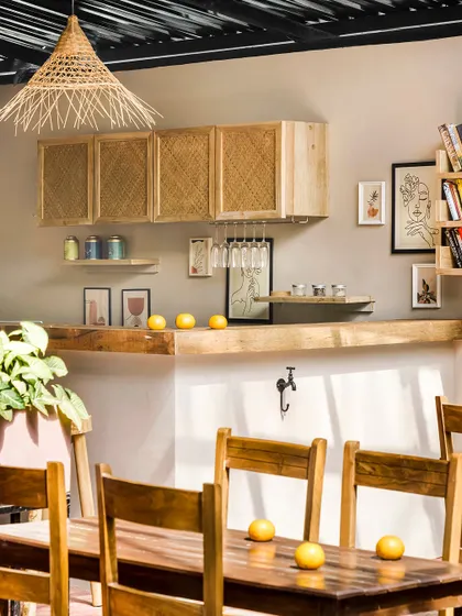 The communal bar and dining area at Unallome is crafted from natural wood and rattan. The space is designed to be simple and functional, allowing the beauty of the materials and the surrounding nature to take center stage.