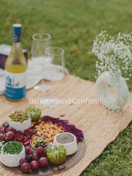 It's all about the details. A close-up of the gourmet grazing platter and wine, set on a rustic jute mat, with a vase of delicate baby's breath completing the aesthetic.
