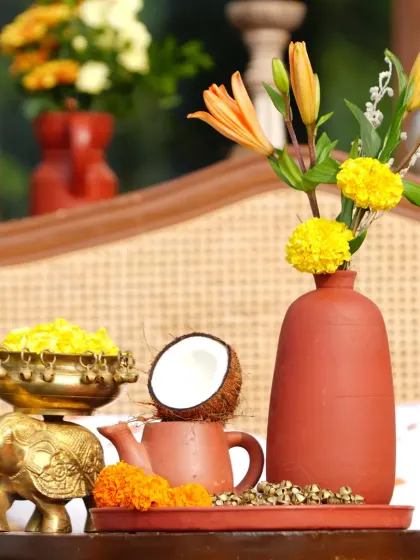 A collection of traditional items for the Haldi ceremony, including a brass elephant bowl for turmeric, a coconut, and marigold flowers, all beautifully arranged.