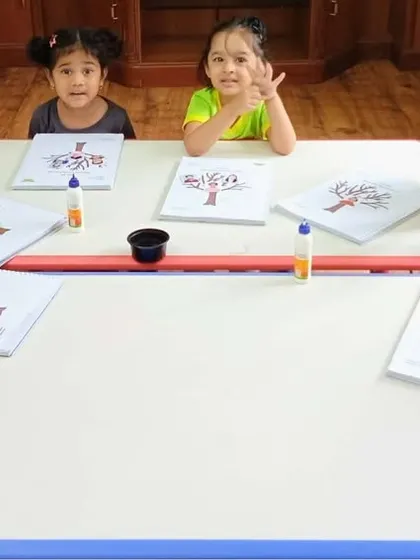 Look at these proud faces. Our little learners are engaged in a worksheet activity, developing pre-writing skills and focus in a supportive group setting.