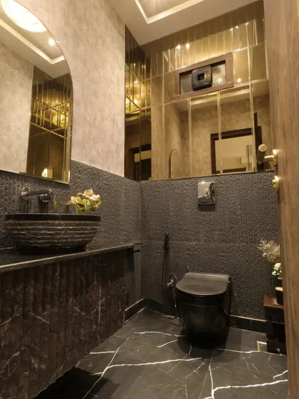 A view of the powder room, highlighting the black marble flooring with white veins and the unique stone-carved sink basin.