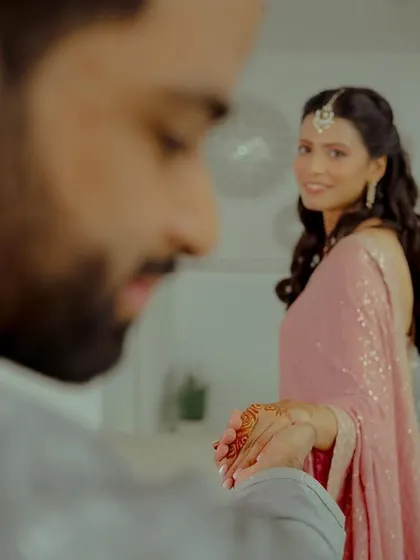 A slightly different angle of the ring ceremony, focusing on the bride's joyful gaze as she looks at her partner.
