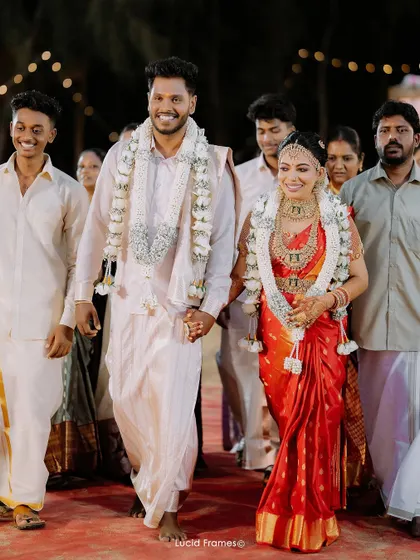 The couple's triumphant exit from the ceremony, hand-in-hand and smiling, surrounded by family.