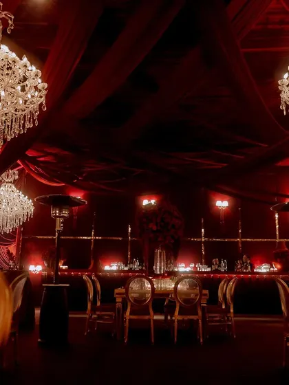 The entire event space was a vision in red, with massive crystal chandeliers hanging from a ceiling of draped fabric. The consistent color scheme and lighting created a powerful, immersive experience.