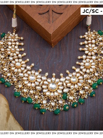 This Jadua Kundan choker with green beads is a beautiful and elegant piece. The floral motifs and intricate stonework are simply stunning.