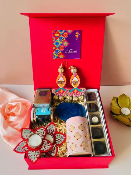 We believe in vibrant, joyful gifting. This classic red magnetic-closure box is filled with a colorful assortment of chocolates, festive door hangings, and decorative t-lights to truly capture the spirit of Diwali.