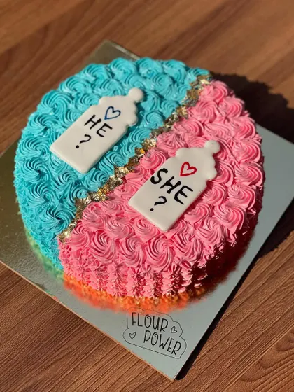 A "He or She?" gender reveal cake, split down the middle with blue and pink buttercream. It's a sweet way to build anticipation for the big reveal.