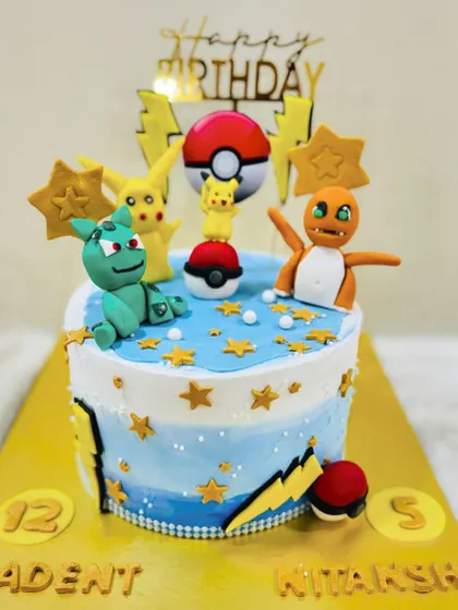 Gotta catch 'em all! This vibrant Pokémon cake features fondant figures of Pikachu, Charmander, and Bulbasaur, complete with Poké Balls for a budding Pokémon trainer.