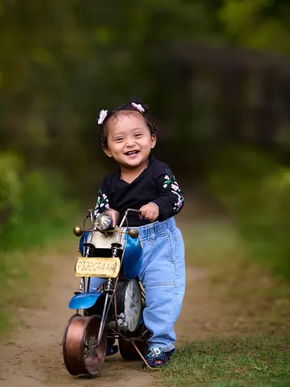 A big smile from this little rider. My collection of props includes this vintage-style toy motorcycle, perfect for adding a cool and fun element to your child's outdoor portrait session.