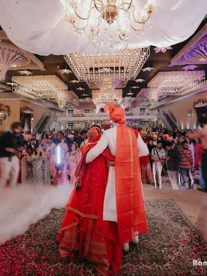 A shot from the back of the couple as they face their guests in a grand hall, capturing the scale of the celebration and their unity.