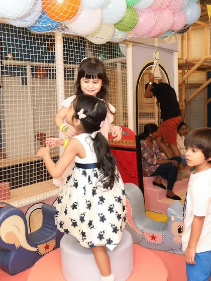 Kids playing and socializing on the soft, padded equipment within the play structure.