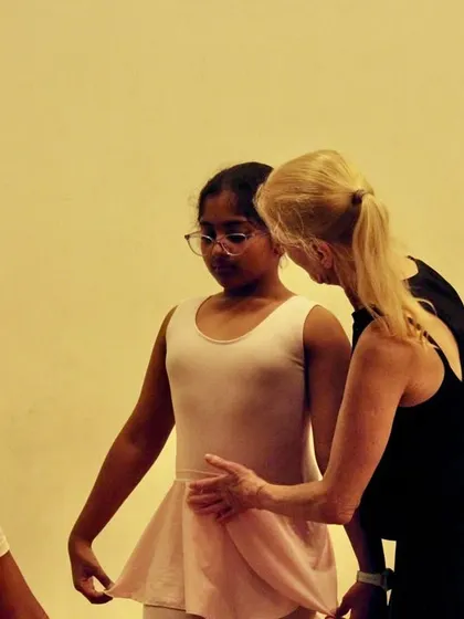 Ms. Yana provides a gentle correction to a Primary student in our Whitefield class. This individual attention is key to helping each dancer understand their body and improve their form.