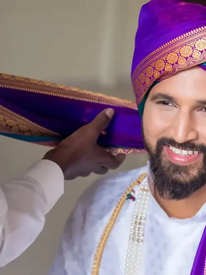 A close-up of the groom's turban being tied, a significant getting-ready ritual that we love to document.