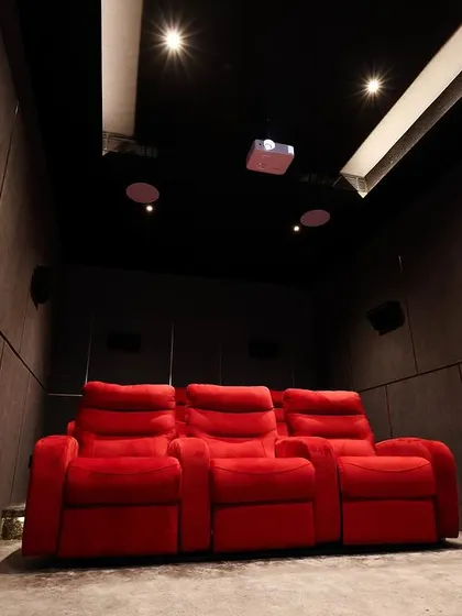 A view from the back of the room, showing the tiered seating and the clean, minimalist design of this dedicated home cinema.