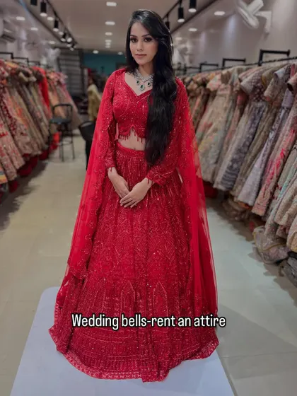 A full look at this fiery red lehenga with cape-style sleeves. It's a modern, powerful, and glamorous outfit available for you to rent and rock.