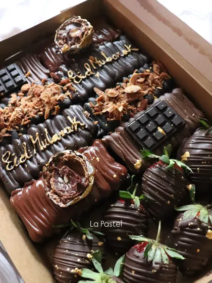 A decadent "Eid Mubarak" dessert box filled with chocolate-covered treats and chocolate-dipped strawberries.