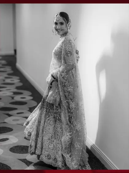 A classic black and white portrait of the bride Muskan, her joyful smile and elegant lehenga captured in timeless monochrome.