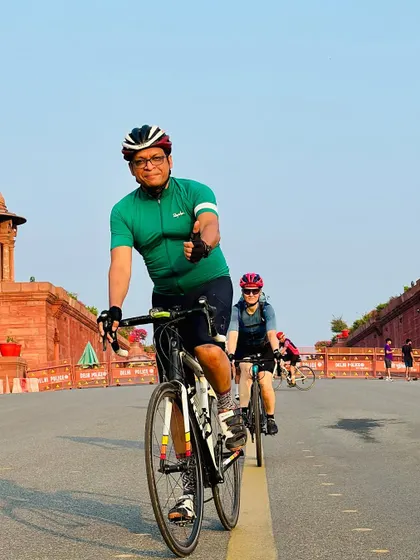 A rider giving a thumbs-up as he rides towards the camera on the iconic Vijay Chowk road.