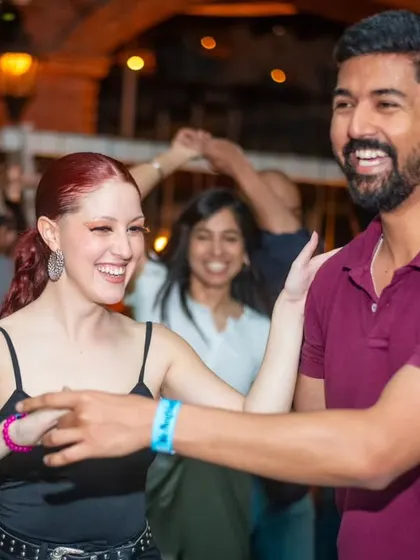 A friendly and joyful interaction between two dancers. Our community is made up of people from all over.