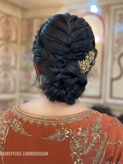 A close-up of a braided bun, this time with a different ornate gold clip. This shows how the same base hairstyle can be transformed with different accessories to match the outfit.