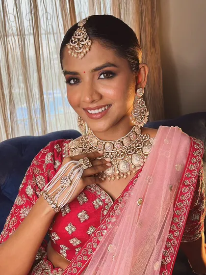 This image captures the complete look, showcasing the harmony between the makeup, the sleek hairstyle, and the traditional bridal attire.
