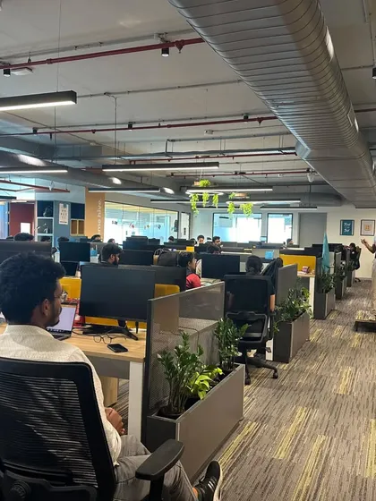 Leading a desk yoga session from a small platform to ensure all participants, even in a large office, can see and follow my instructions.