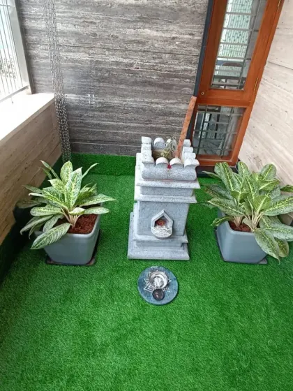 For this balcony, I installed a small section of artificial grass to create a dedicated green corner for plants and a small shrine, adding a peaceful touch.