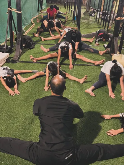 The coach demonstrating a full middle split, showing the level of flexibility that is possible with dedicated training.