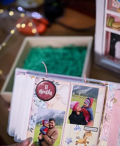 A peek inside the album, showing the '11 months' page filled with sweet family photos.