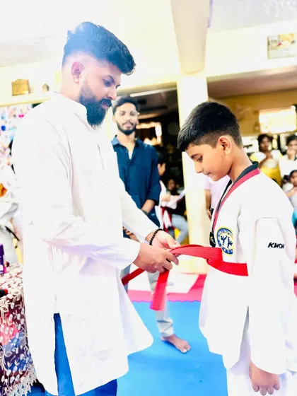 A proud moment for this young student, earning his red belt.