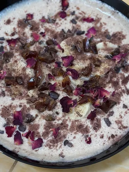 This creamy coconut-almond milk smoothie bowl is a dessert in itself. It has a whole fruit base and is garnished with dates, rose petals, and cacao nibs for a rich, decadent flavor.