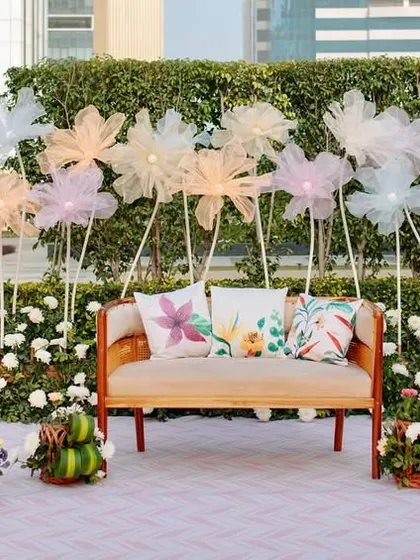 A wider view of the Haldi stage, showing the beautiful arrangement of fabric flowers that create a magical, meadow-like effect.