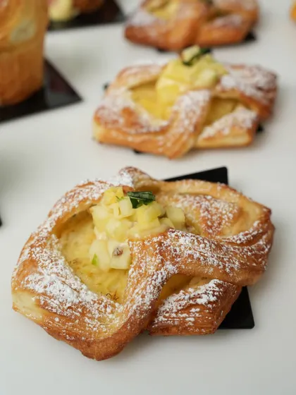 A close-up of a fruit-filled Danish pastry, showcasing the flaky layers of puff pastry and the delicious filling. This is another classic you will learn to master.
