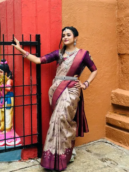 This full-length shot shows how the layered CZ stone necklaces and waist belt come together to create a cohesive and elegant look with a traditional saree.